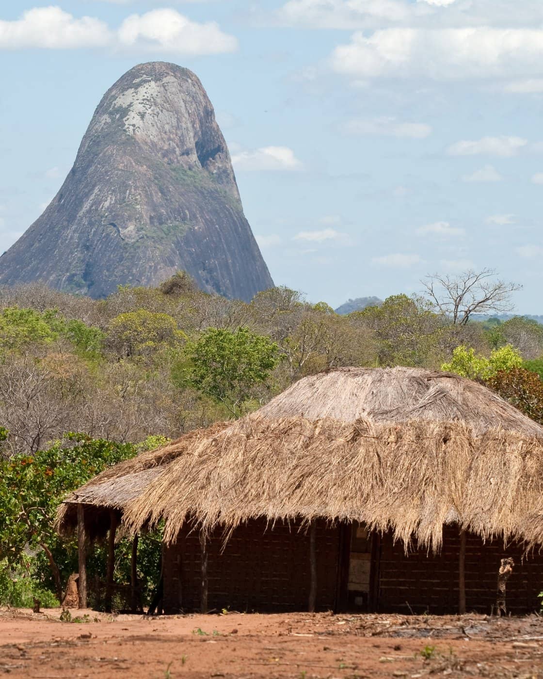 A thatched hut beneath a granite inselberg in Nampula province, Mozambique.
